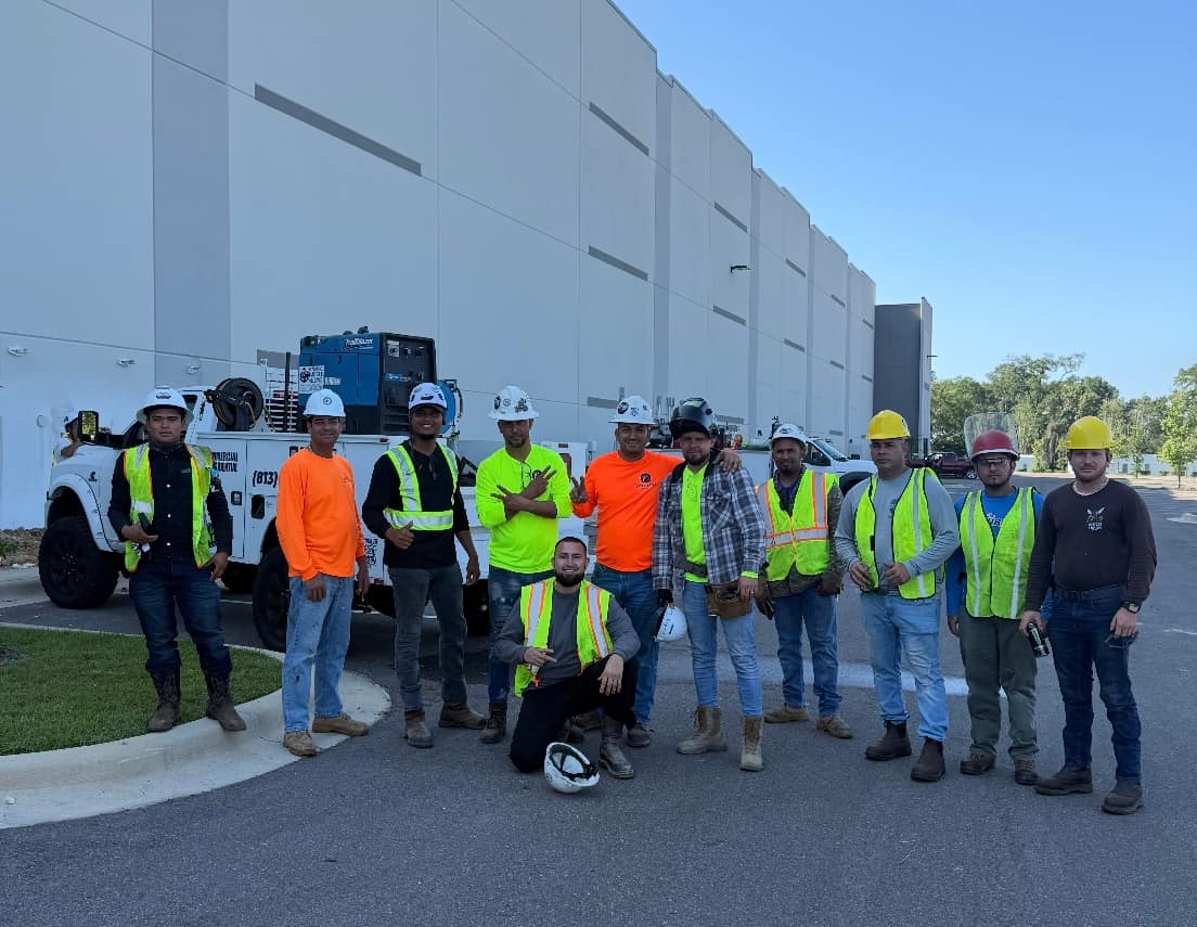 Construction workers in hi-vis vests and hard hats outside the distribution center at the end of a shift