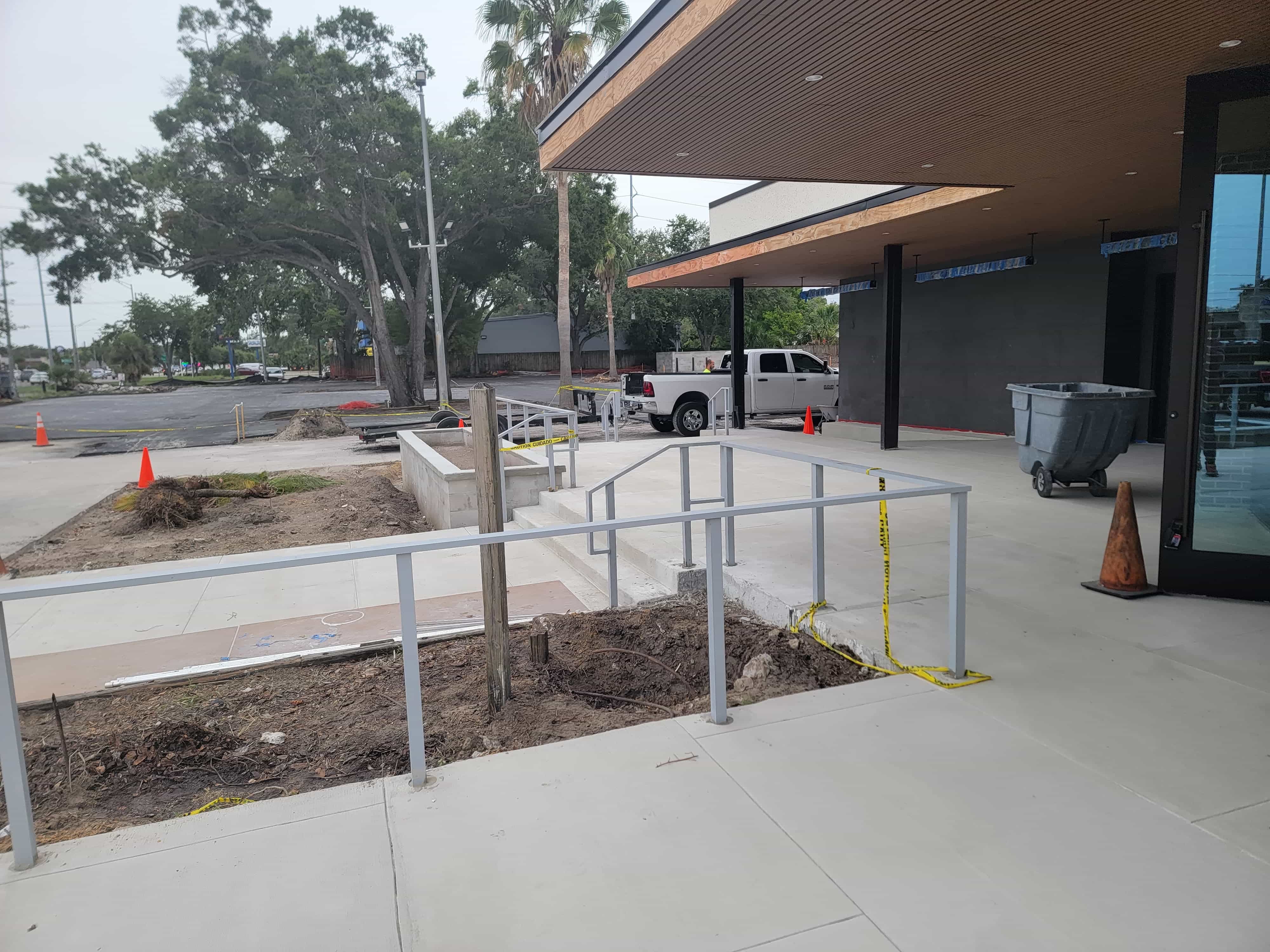 Painted steel handrails and guardrails installed at a commercial entrance ramp and steps