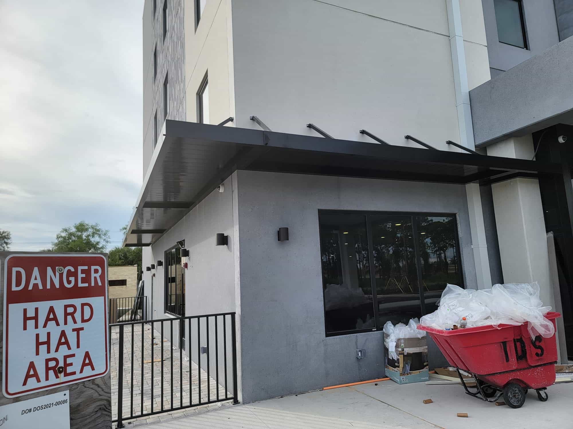 Cantilevered steel canopy with tie-back arms installed over a commercial entrance